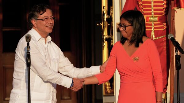 O presidente colombiano, Gustavo Petro, à esquerda, e a presidente interina da Venezuela, Delcy Rodríguez, apertam as mãos após uma reunião no Palácio de Miraflores. Caracas, Venezuela, 24 de abril de 2026 - Sputnik Brasil
