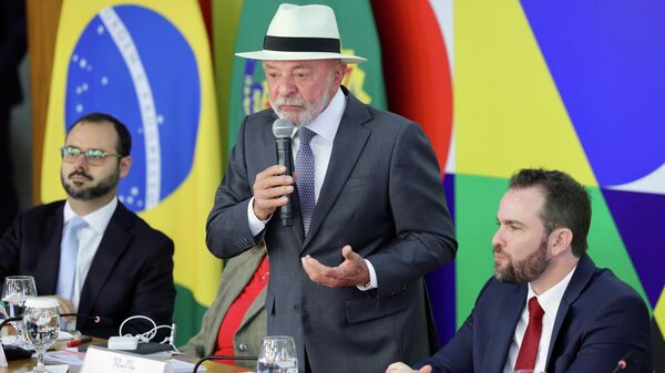 O presidente brasileiro Luiz Inácio Lula da Silva, acompanhado dos ministros do Empreendedorismo, da Microempresa e da Empresa de Pequeno Porte, Paulo Henrique Rodrigues (E), da Casa Civil, Miriam Belchior (atrás de Lula), da Fazenda, Dário Durigan (D) e do Planejamento, Bruno Moretti (fora da imagem), assina Medida Provisória referente ao Novo Desenrola Brasil, Brasília, 4 de maio de 2026 - Sputnik Brasil