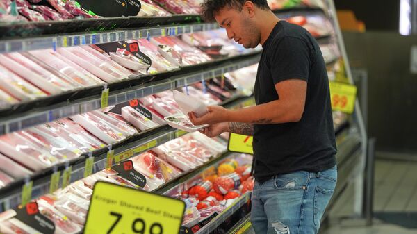Uma cliente observa embalagens de carne em um supermercado em Dallas, 15 de abril de 2026 - Sputnik Brasil