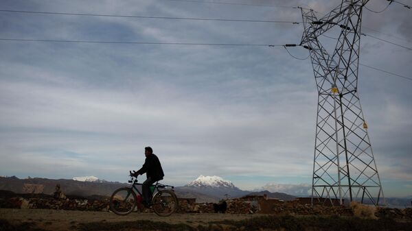 Homem passa de bicicleta por linha de transmissão de energia elétrica em El Alto. Bolívia, 1º de maio de 2012 - Sputnik Brasil
