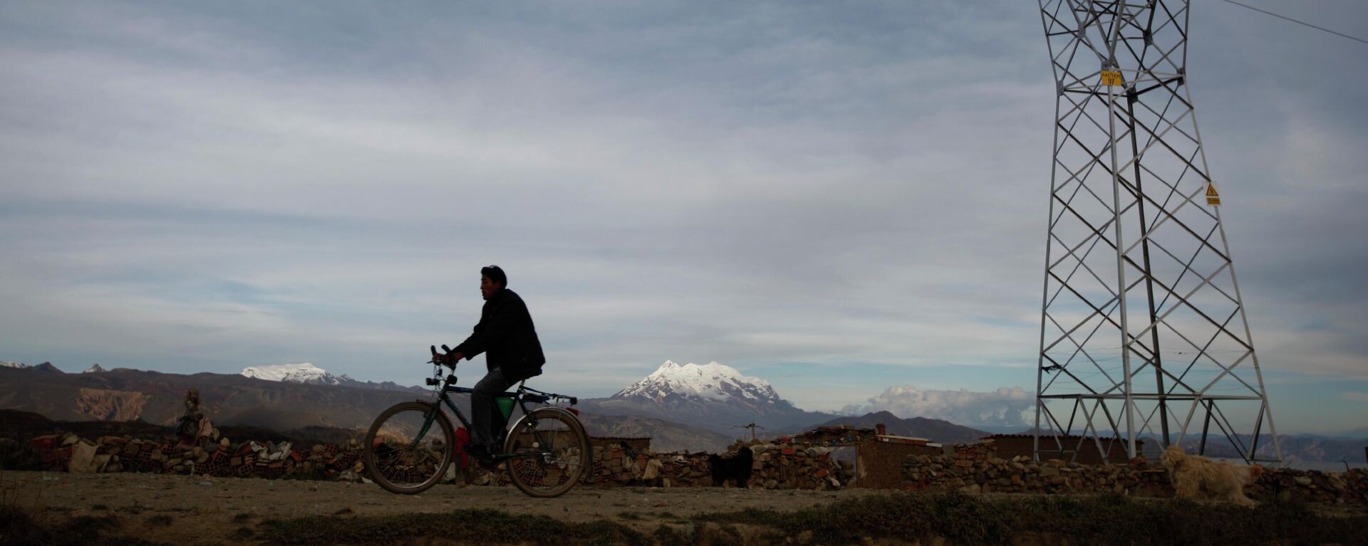 Homem passa de bicicleta por linha de transmissão de energia elétrica em El Alto. Bolívia, 1º de maio de 2012 - Sputnik Brasil, 1920, 07.05.2026