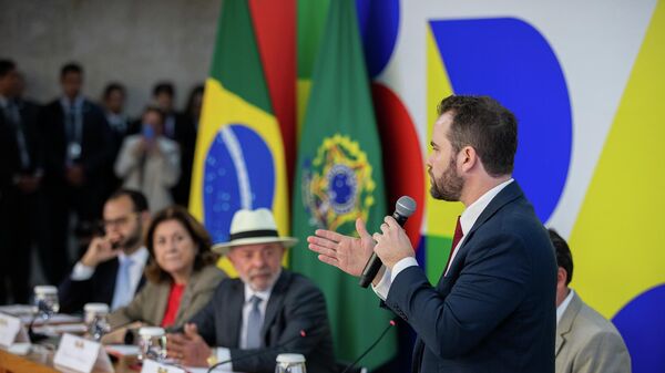 Sob olhar atento do presidente do Brasil, Luiz Inácio Lula da Silva, o ministro da Fazenda, Dario Durigan, comenta expansão do Desenrola, em 4 de maio de 2026 - Sputnik Brasil