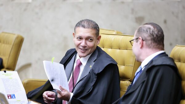 O ministro do Supremo Tribunal Federal (STF) Kassio Nunes Marques (à esq.) conversa com o colega de Corte Cristiano Zanin (à dir.) durante sessão plenária, em 30 de abril de 2026 - Sputnik Brasil