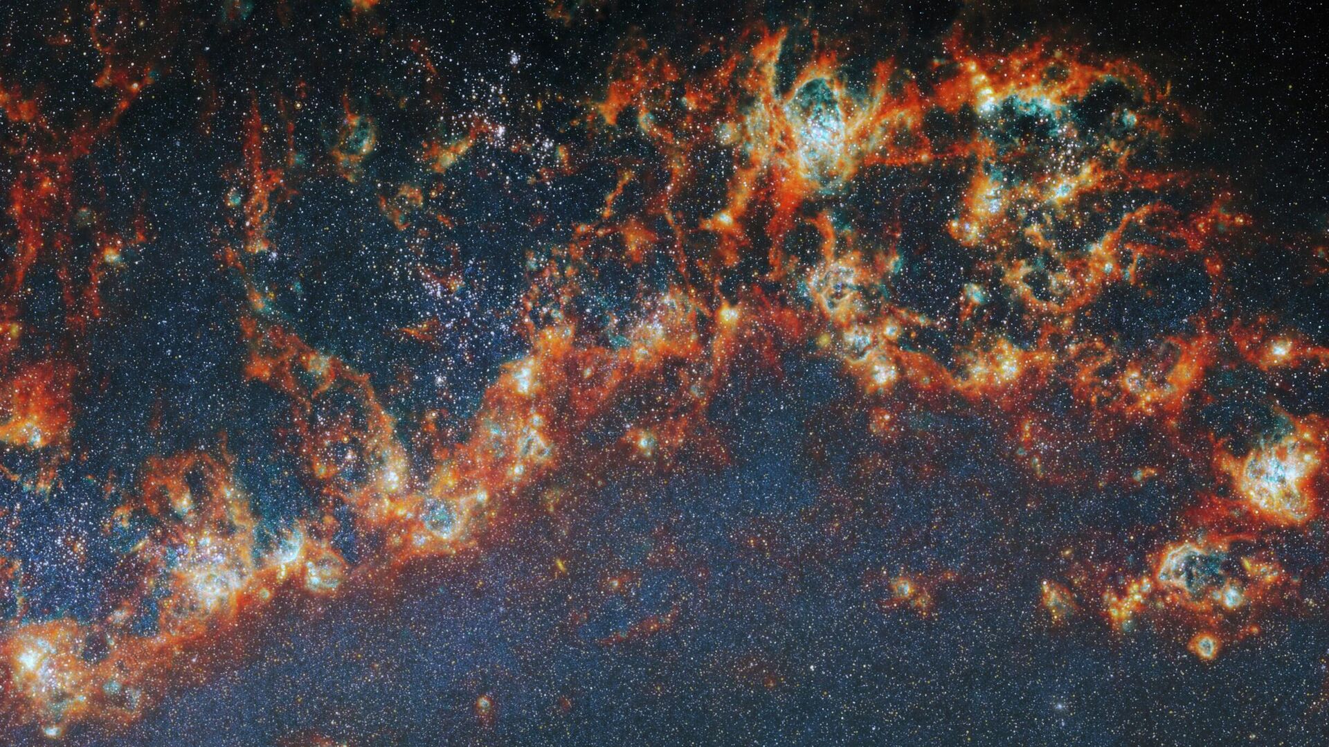A imagem mostra uma grande e longa porção de um dos braços espirais da galáxia M51. Filamentos aglomerados de gás e poeira vermelho-alaranjados, que se estendem em cadeia da esquerda para a direita, compõem o braço. Bolhas ciano brilhantes iluminam partes das nuvens de gás por dentro, e lacunas expõem aglomerados estelares brilhantes nessas bolhas como pontos brancos luminosos. Toda a imagem é pontilhada por pequenas estrelas. Um tênue brilho azul ao redor do braço colore o fundo escuro A imagem mostra uma grande e longa porção de um dos braços espirais da galáxia M51. Filamentos aglomerados de gás e poeira vermelho-alaranjados, que se estendem em cadeia da esquerda para a direita, compõem o braço. Bolhas ciano brilhantes iluminam partes das nuvens de gás por dentro, e lacunas expõem aglomerados estelares brilhantes nessas bolhas como pontos brancos luminosos. Toda a imagem é pontilhada por pequenas estrelas. Um tênue brilho azul ao redor do braço colore o fundo escuro - Sputnik Brasil, 1920, 12.05.2026
