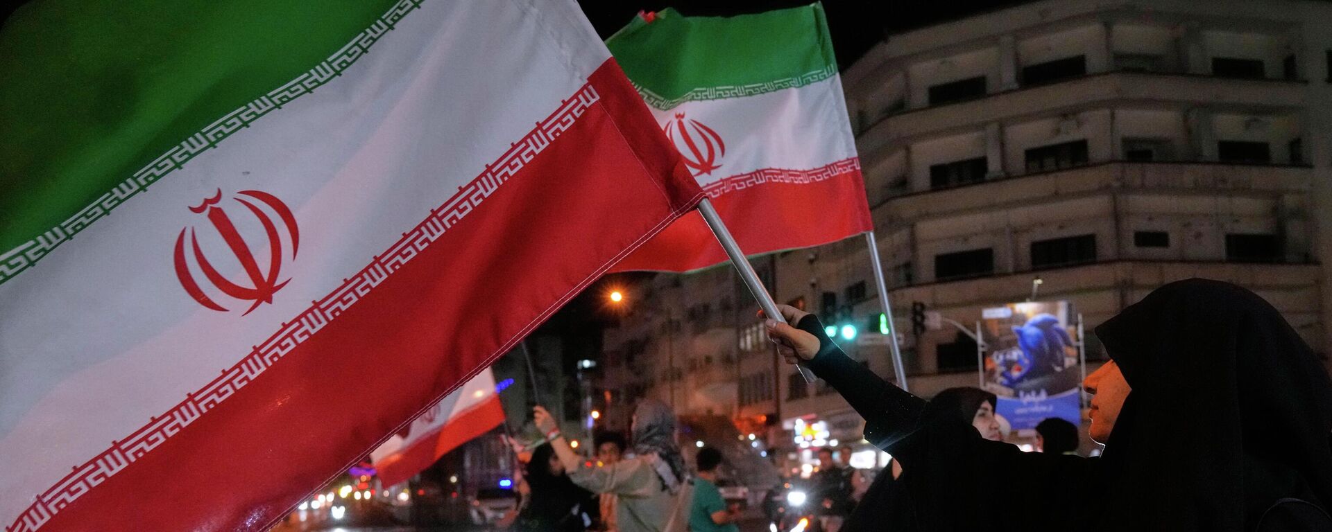 Mulher iraniana segura a bandeira do país em protestos a favor do governo local, em Teerã, em 8 de maio de 2026 - Sputnik Brasil, 1920, 12.05.2026