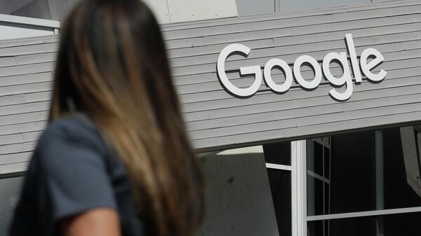 Uma mulher caminha sob uma placa do Google no campus em Mountain View, Califórnia - Sputnik Brasil