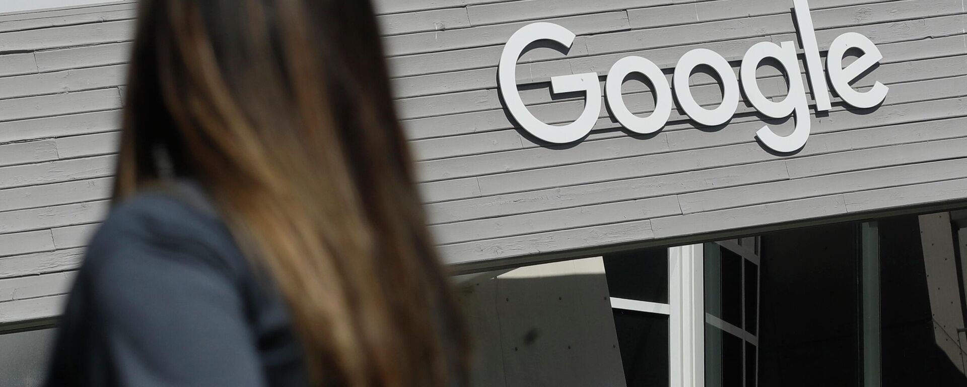 Uma mulher observa uma placa do Google no campus em Mountain View, Califórnia - Sputnik Brasil, 1920, 19.05.2026
