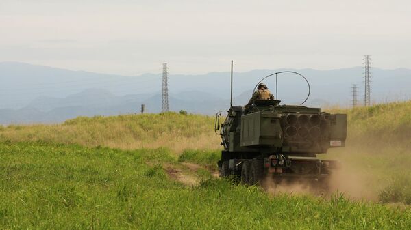 Fuzileiros navais dos EUA partem em um caminhão militar com o sistema de foguetes de artilharia de alta mobilidade (Himars) montado após realizarem treinamento de tiro real durante uma visita da imprensa ao Campo Fuji, em Gotemba, sudoeste de Tóquio, 20 de maio de 2026 - Sputnik Brasil