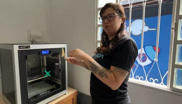 Luíza Carmelo, coordenadora pedagógica do instituto FuturoON, mostra funcionamento de uma impressora 3D. São Gonçalo, 29 de maio de 2026 - Sputnik Brasil