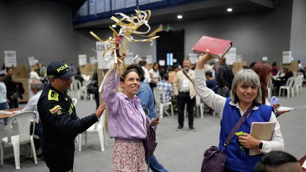 Um policial diz a mulheres que entoavam slogans religiosos que fazer campanha não é permitido em uma seção eleitoral durante a eleição presidencial em Bogotá, Colômbia. - Sputnik Brasil