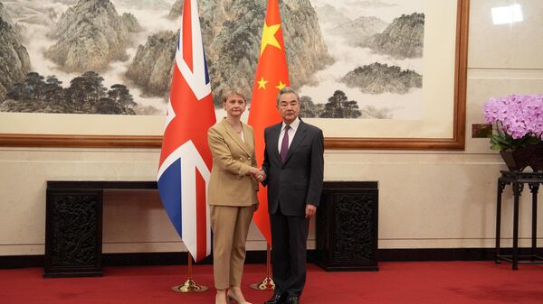 A secretária de Relações Exteriores britânica Yvette Cooper e o ministro das Relações Exteriores chinês Wang Yi durante uma reunião em Pequim - Sputnik Brasil