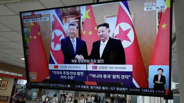 Tela de TV exibe imagem do presidente chinês Xi Jinping e do líder norte-coreano Kim Jong-un durante um programa de notícias - Sputnik Brasil