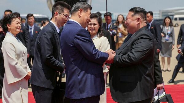 O líder norte-coreano Kim Jong-un (D) cumprimenta o presidente chinês Xi Jinping (E) durante sua visita oficial de Estado à Coreia do Norte - Sputnik Brasil