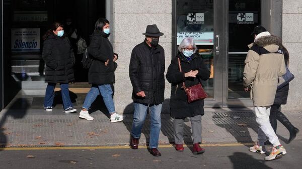 Pessoas usando máscaras faciais como precaução caminham na entrada de um hospital em Madri, Espanha, 8 de janeiro de 2024 - Sputnik Brasil