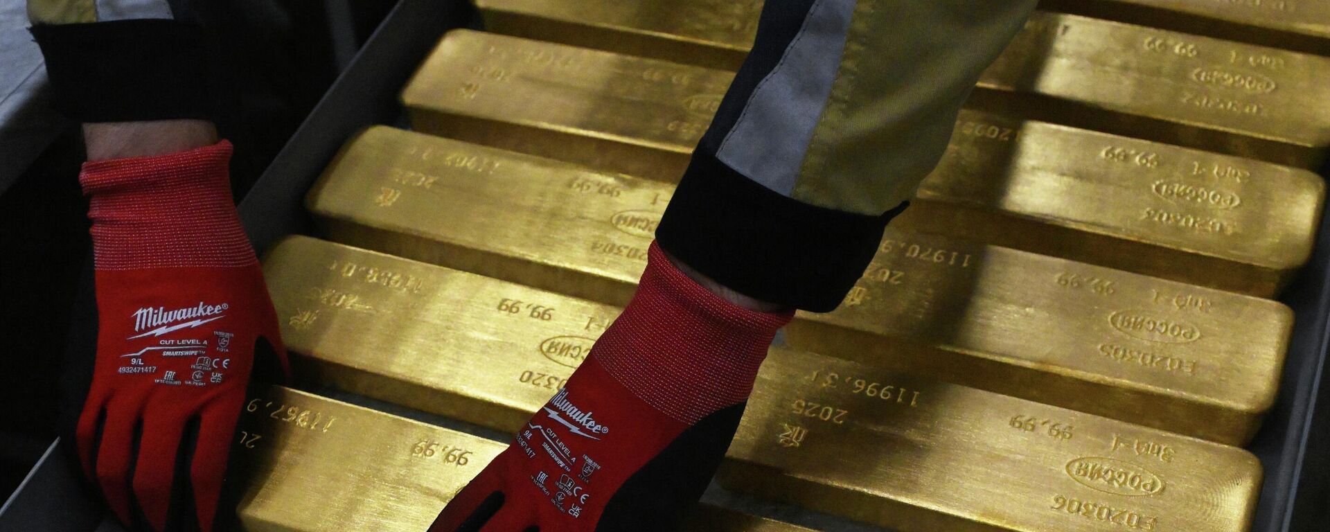 Um funcionário coloca barras de ouro acabadas e marcadas, com pureza de 99,99%, em um carrinho na Usina de Metais Não Ferrosos V.N. Gulidov de Krasnoyarsk (Krastsvetmet), a maior refinadora em escala industrial do mundo de todos os metais do grupo da platina (platina, paládio, ródio, irídio, rutênio e ósmio), bem como de ouro e prata. Foto de 26 de junho de 2025 - Sputnik Brasil, 1920, 12.06.2026