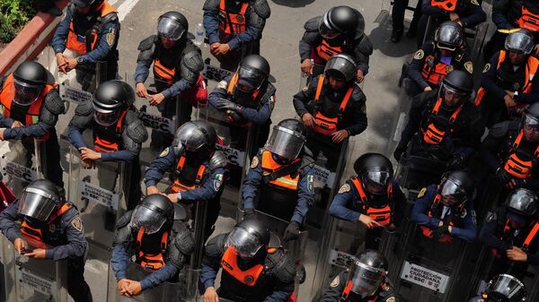 Policiais com escudos se preparam para conter manifestantes na Cidade do México, em 11 de junho de 2026 - Sputnik Brasil