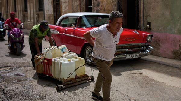 Cubanos transportam galões com água por Havana, em 3 de junho de 2026 - Sputnik Brasil