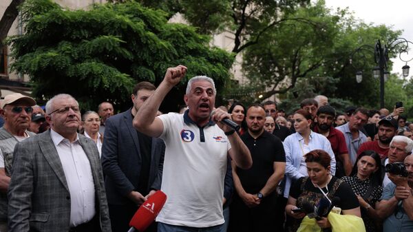 Homem gesticula enquanto conversa com manifestantes de partidos da oposição, em protesto contra os resultados das eleições parlamentares em Yerevan. Armênia, 14 de junho de 2026 - Sputnik Brasil