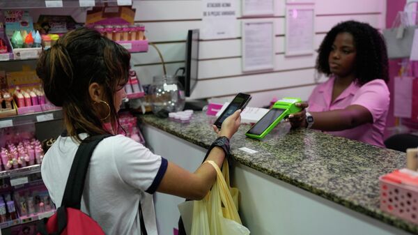 Mulher faz pagamento por Pix em loja no Rio de Janeiro, em 16 de abril de 2026 - Sputnik Brasil