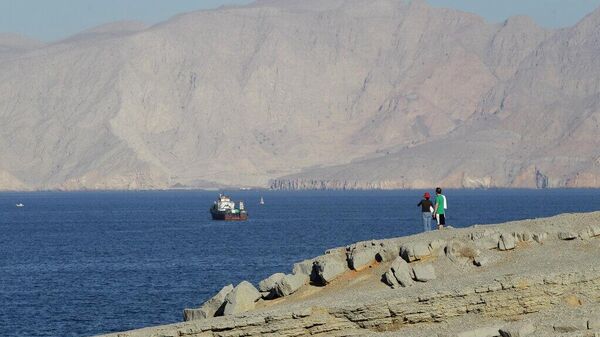 Um casal de turistas contempla as montanhas ao sul do estreito de Ormuz, enquanto dhows e navios mercantes atracam nas águas do Golfo Pérsico, perto da cidade de Khasab, em Omã - Sputnik Brasil
