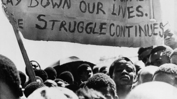 Uma faixa é erguida acima de estudantes negros em Joanesburgo, no bairro de Soweto, onde se reuniram após o funeral de um estudante negro de 16 anos que morreu na prisão. África do Sul, 18 de outubro de 1976 - Sputnik Brasil