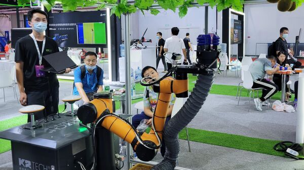 Visitantes observam o funcionamento de um dos expositores na Conferência Mundial de Robótica (World Robot Conference) em Pequim, China - Sputnik Brasil