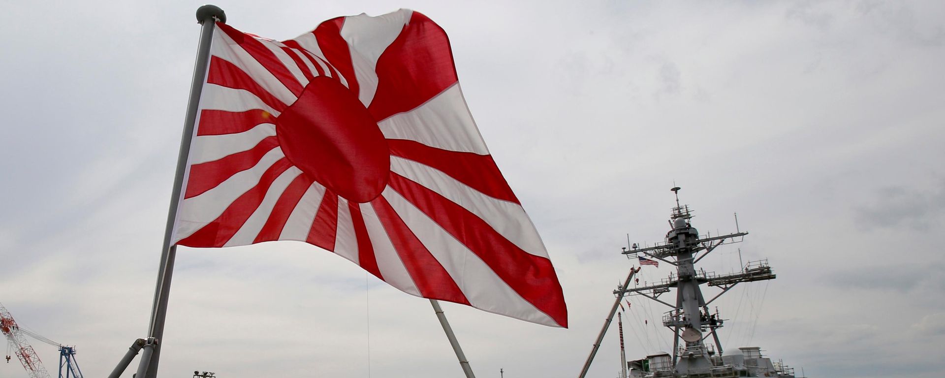A bandeira militar do Japão — a Bandeira do Sol Nascente — tremula no navio de desembarque de tanques JS Kunisaki, da Força de Autodefesa Marítima do Japão, ancorado em Yokosuka, perto de Tóquio, em 27 de maio de 2014 A bandeira militar do Japão — a Bandeira do Sol Nascente — tremula no navio de desembarque de tanques JS Kunisaki, da Força de Autodefesa Marítima do Japão, ancorado em Yokosuka, perto de Tóquio, em 27 de maio de 2014 - Sputnik Brasil, 1920, 25.07.2026