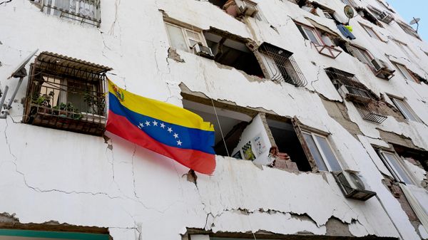 Uma bandeira da Venezuela é hasteada do lado de fora de um prédio danificado pelos terremotos de 24 de junho, em Catia La Mar, em 26 de junho de 2026 - Sputnik Brasil