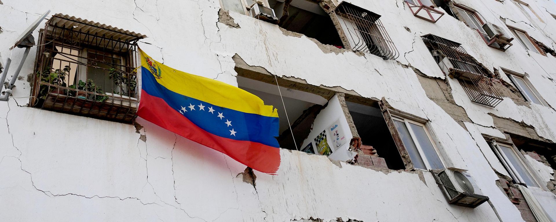 Uma bandeira da Venezuela é hasteada do lado de fora de um prédio danificado pelos terremotos de 24 de junho, em Catia La Mar, em 26 de junho de 2026 - Sputnik Brasil, 1920, 26.06.2026