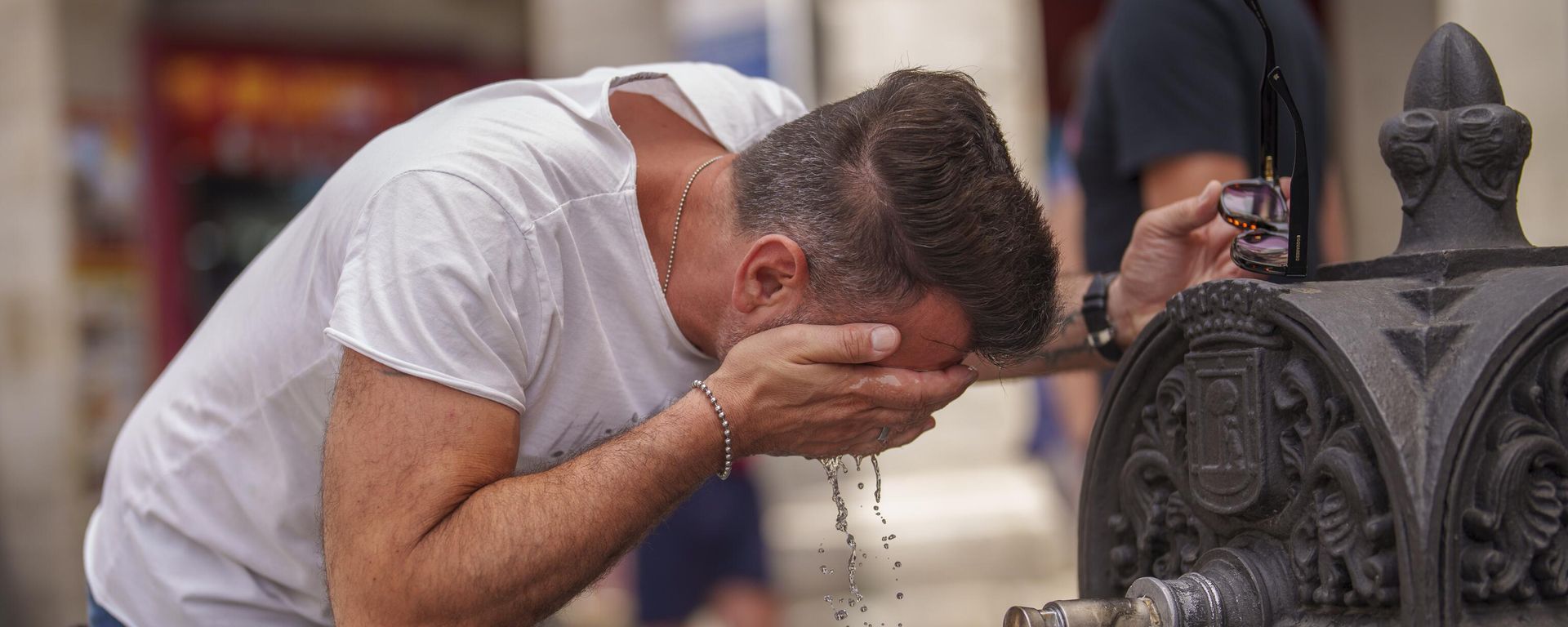 Um homem se refresca em uma fonte durante um dia quente e ensolarado de verão em Madri, Espanha, 19 de julho de 2023 - Sputnik Brasil, 1920, 29.06.2026