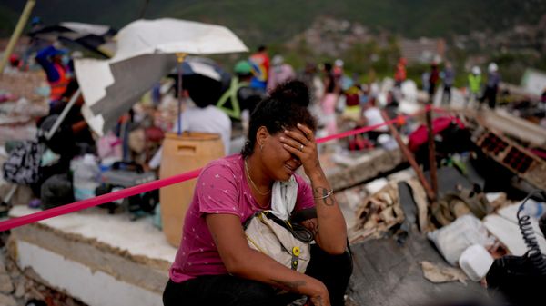 Venezuelana chora em meio aos escombros de prédio que colapsou após terremotos em La Guaira, em 30 de junho de 2026 - Sputnik Brasil