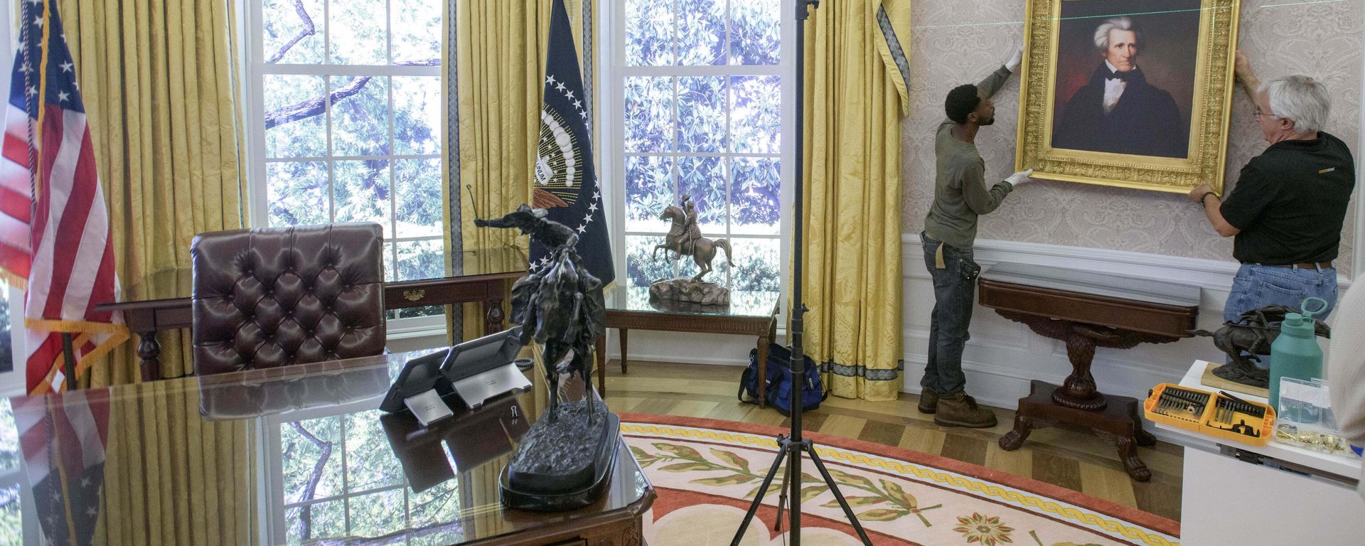 Melvin Dorsey (E) e Tim Boyd trabalham na instalação de retratos durante a transição de uma réplica do Salão Oval da Casa Branca da época do ex-presidente Joe Biden para a decoração do presidente Donald Trump, na Associação Histórica da Casa Branca em Washington, 23 de julho de 2025 - Sputnik Brasil, 1920, 09.07.2026