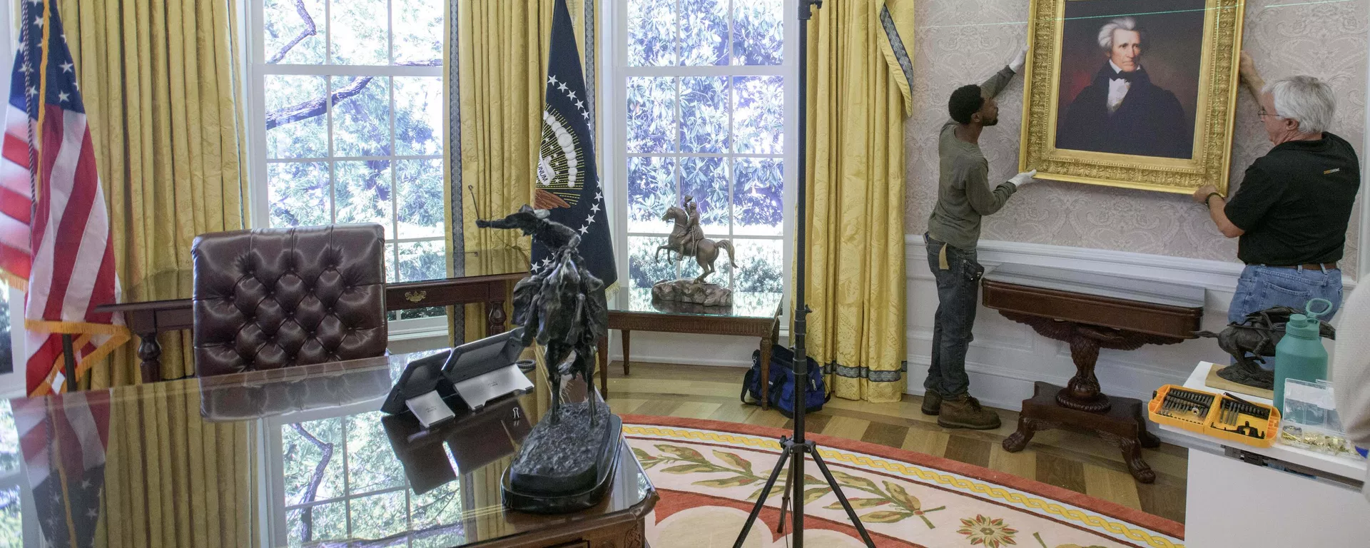 Melvin Dorsey (E) e Tim Boyd trabalham na instalação de retratos durante a transição de uma réplica do Salão Oval da Casa Branca da época do ex-presidente Joe Biden para a decoração do presidente Donald Trump, na Associação Histórica da Casa Branca em Washington, 23 de julho de 2025 - Sputnik Brasil, 1920, 09.07.2026