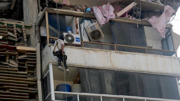 Resgatista escala prédio destruído em La Guaira, na Venezuela, em 6 de julho de 2026 - Sputnik Brasil