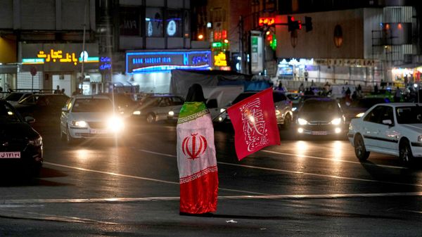 Uma manifestante pró-governo usa uma bandeira do Irã enquanto segura uma bandeira religiosa durante uma concentração em homenagem ao falecido líder supremo iraniano, aiatolá Ali Khamenei, em uma praça de Teerã, Irã, em 11 de julho de 2026 - Sputnik Brasil