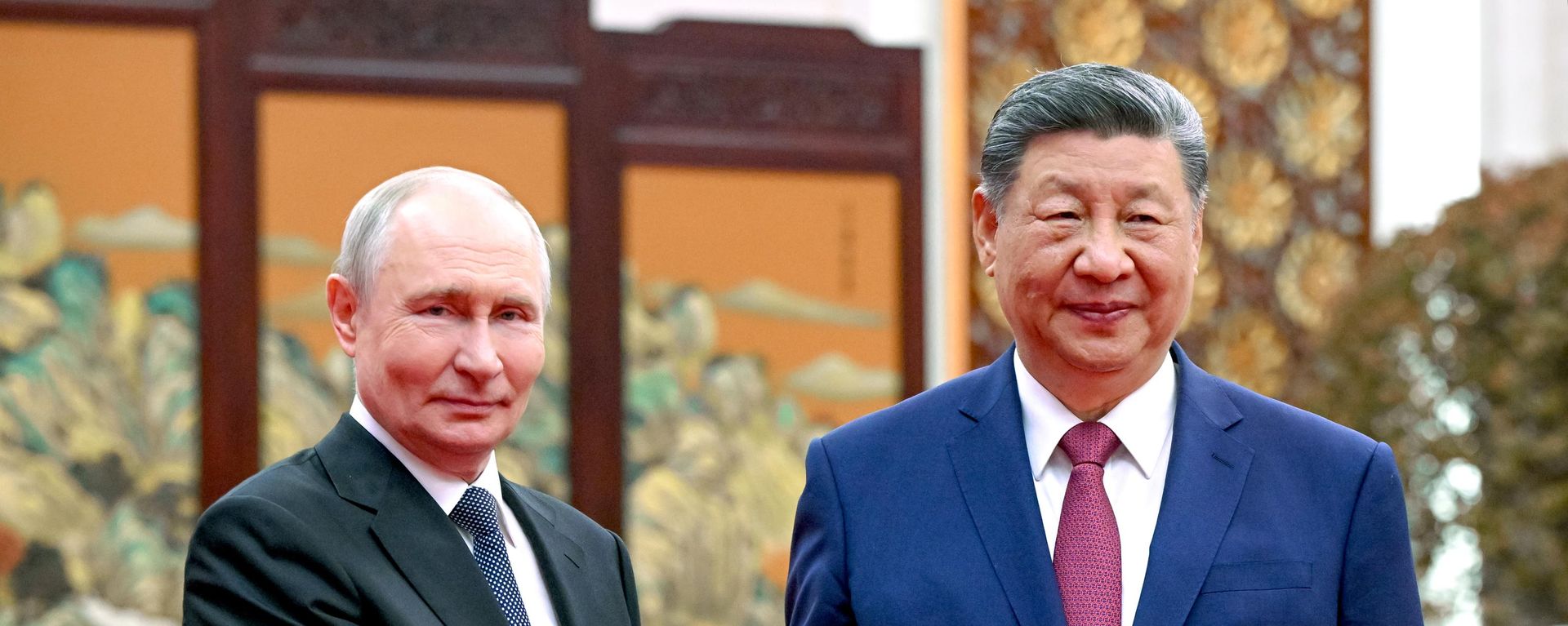 Os presidentes da Rússia, Vladimir Putin (à esq.), e da China, Xi Jinping (à dir.), torcam aperto de mão durante encontro em Pequim. China, 20 de maio de 2026 - Sputnik Brasil, 1920, 16.07.2026