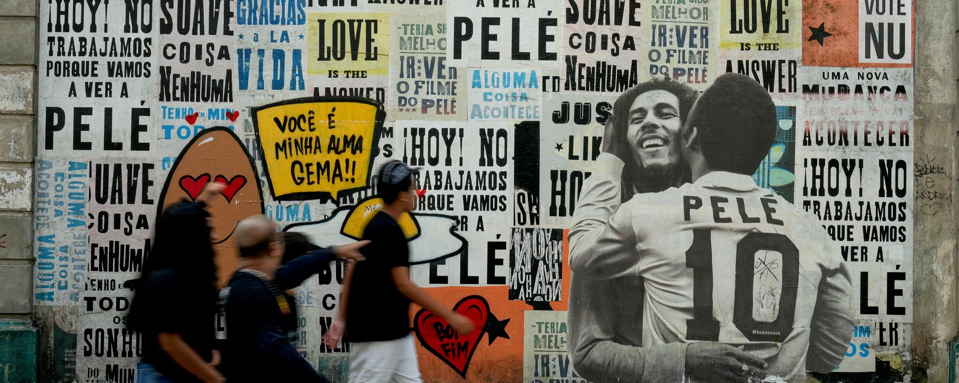 Pessoas passam diante de um mural da falecida lenda do futebol Pelé e do cantor de reggae Bob Marley, em Santos, Brasil. - Sputnik Brasil, 1920, 19.07.2026
