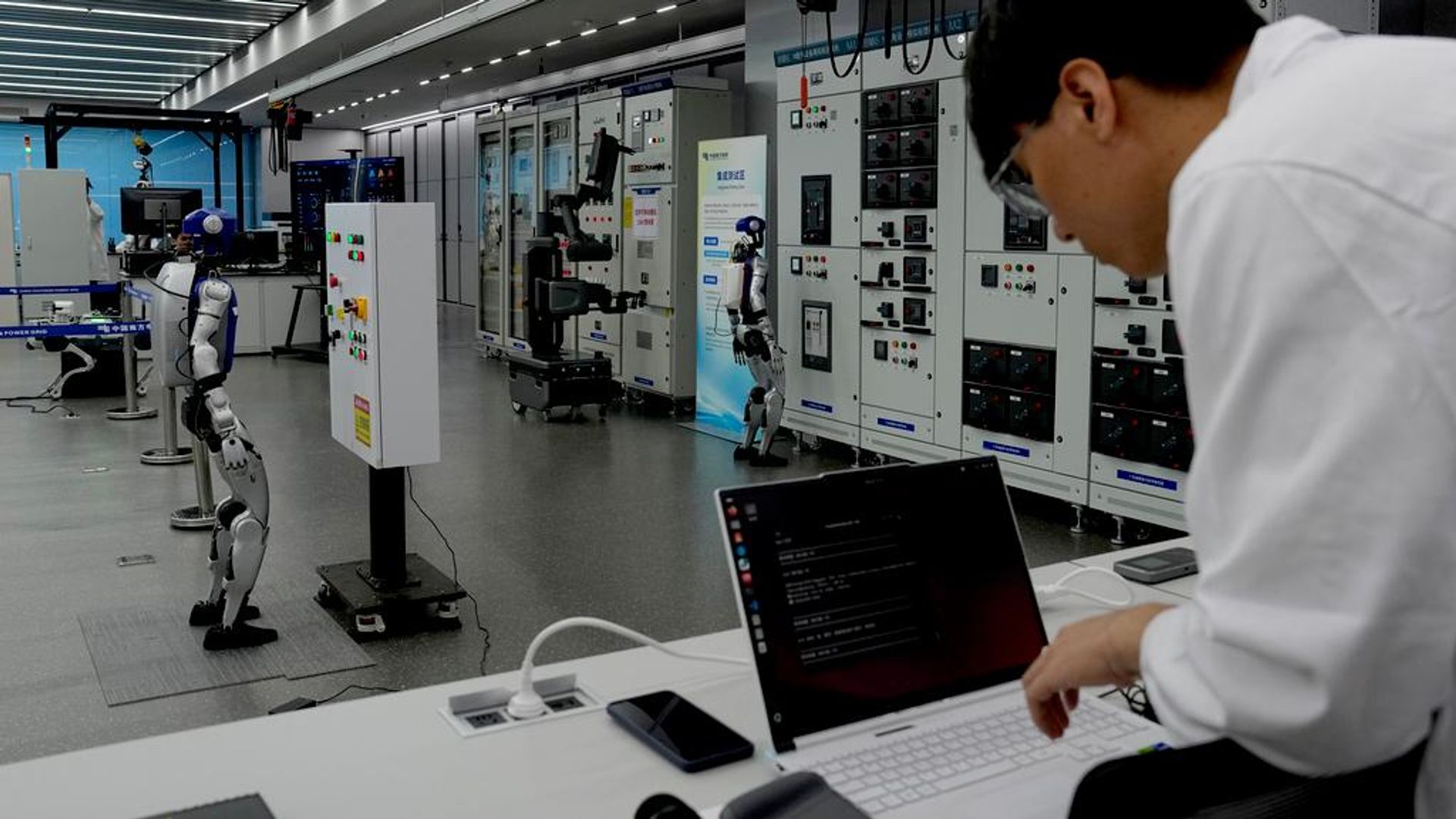 Um funcionário utiliza um computador portátil enquanto robôs de inteligência artificial (IA) demonstram o funcionamento do centro de controle da rede elétrica durante uma visita guiada organizada pela imprensa ao Laboratório de Robótica da Rede Elétrica de Guangdong, em Guangzhou, província de Guangdong, no sul da China, 16 de abril de 2026 Um funcionário utiliza um computador portátil enquanto robôs de inteligência artificial (IA) demonstram o funcionamento do centro de controle da rede elétrica durante uma visita guiada organizada pela imprensa ao Laboratório de Robótica da Rede Elétrica de Guangdong, em Guangzhou, província de Guangdong, no sul da China, 16 de abril de 2026 - Sputnik Brasil, 1920, 19.07.2026