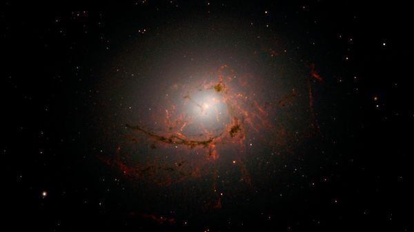 Esta imagem, captada pela Wide Field Camera 3 (WFC3) do Hubble, mostra NGC 4696, a maior galáxia do Aglomerado de Centauro. As novas imagens revelam, com detalhes inéditos, os filamentos de poeira que envolvem o centro dessa enorme galáxia. Esses filamentos se curvam e espiralam para dentro em uma forma intrigante, girando ao redor do buraco negro supermassivo a tal distância que acabam sendo arrastados e, eventualmente, consumidos por ele - Sputnik Brasil
