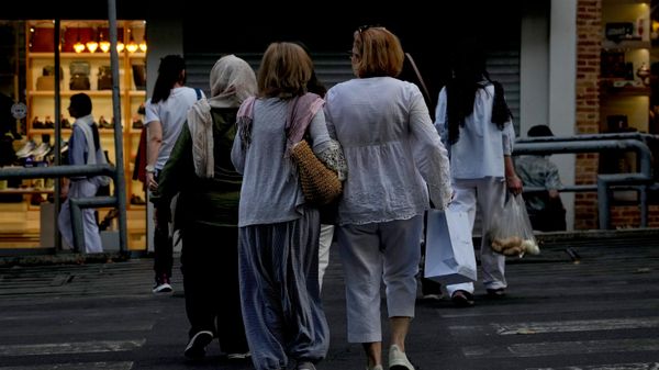 Mulheres atravessam a rua com sacolas em Teerã, capital do Irã, em 13 de julho de 2026 - Sputnik Brasil