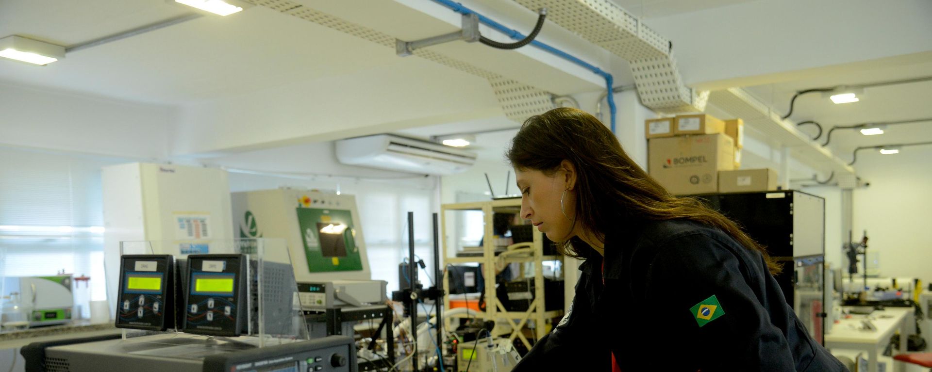 A pesquisadora Cristiane Mesquita demonstra um equipamento para a criação da ilha de policogeração sustentável, capaz de gerar eletricidade, água destilada, biocombustível e outros insumos na COPPE/UFRJ. Projeto é financiado por empresas e conta com apoio da Marinha - Sputnik Brasil, 1920, 24.07.2026