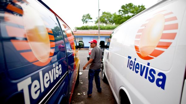 Um policial nicaraguense à paisana entre duas vans com o logotipo da emissora mexicana Televisa, em Manágua, Nicarágua, em 29 de agosto de 2012 - Sputnik Brasil