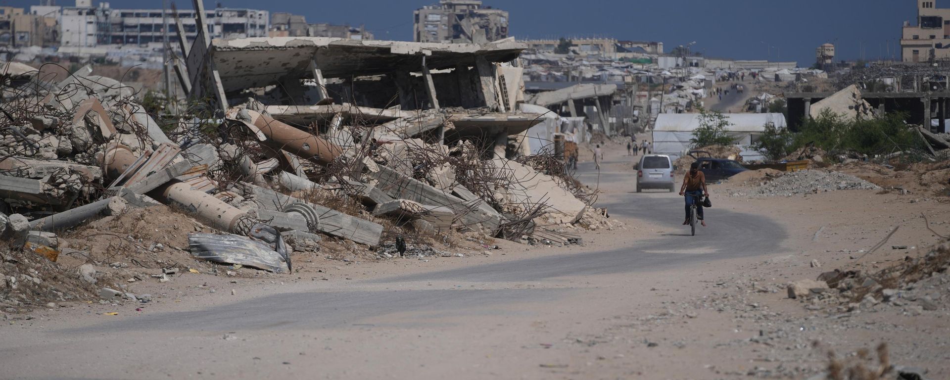 Palestino anda de bicicleta em meio aos escombros de prédios na Faixa de Gaza, em 31 de julho de 2026 - Sputnik Brasil, 1920, 01.08.2026