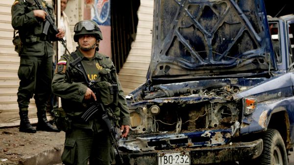 Policiais estão diante de um carro danificado no local onde supostos rebeldes explodiram uma agência de um banco estatal de desenvolvimento agrícola em Corinto, no sul da Colômbia, em 26 de abril de 2010 - Sputnik Brasil