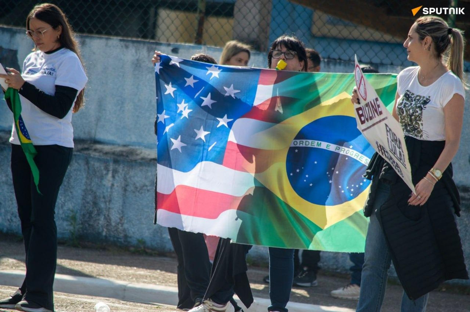 Opositores de Lula protestam na entrada de evento com bandeira dos EUA