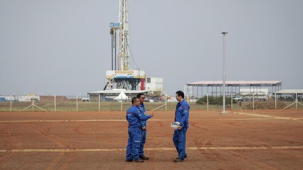Trabalhadores chineses da Corporação Nacional de Petróleo Offshore da China (CNOOC, na sigla em inglês) posam em frente à plataforma de perfuração no campo petrolífero de Kingfisher, às margens do Lago Albert, no distrito de Kikuube, oeste de Uganda, 24 de janeiro de 2023 - Sputnik Brasil