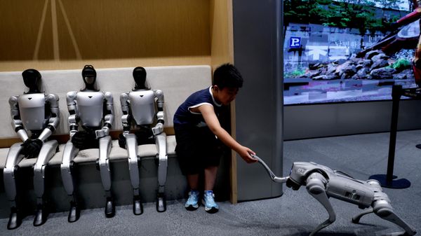 Uma criança se senta ao lado dos robôs humanoides G1 da Unitree enquanto interage com um robô GO2 da mesma fabricante, em uma loja física da empresa em Pequim, China, 1º de agosto de 2026 - Sputnik Brasil
