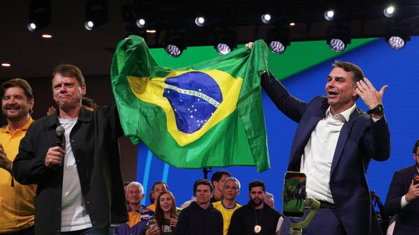O governador de São Paulo, Tarcísio de Freitas (Republicanos), e o senador Flávio Bolsonaro (PL-RJ) seguram bandeira do Brasil durante convenção do PL, em 25 de julho de 2026 - Sputnik Brasil