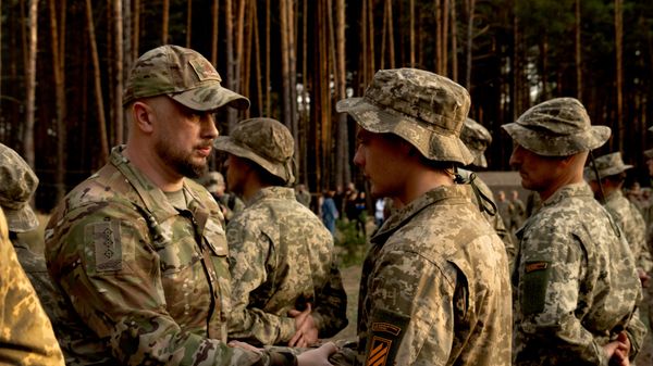 Andrei Biletsky, comandante da 3ª Brigada de Assalto da Ucrânia (à esquerda), aperta a mão de soldados recém-recrutados em uma base militar perto de Kiev. Ucrânia, 25 de setembro de 2023 - Sputnik Brasil