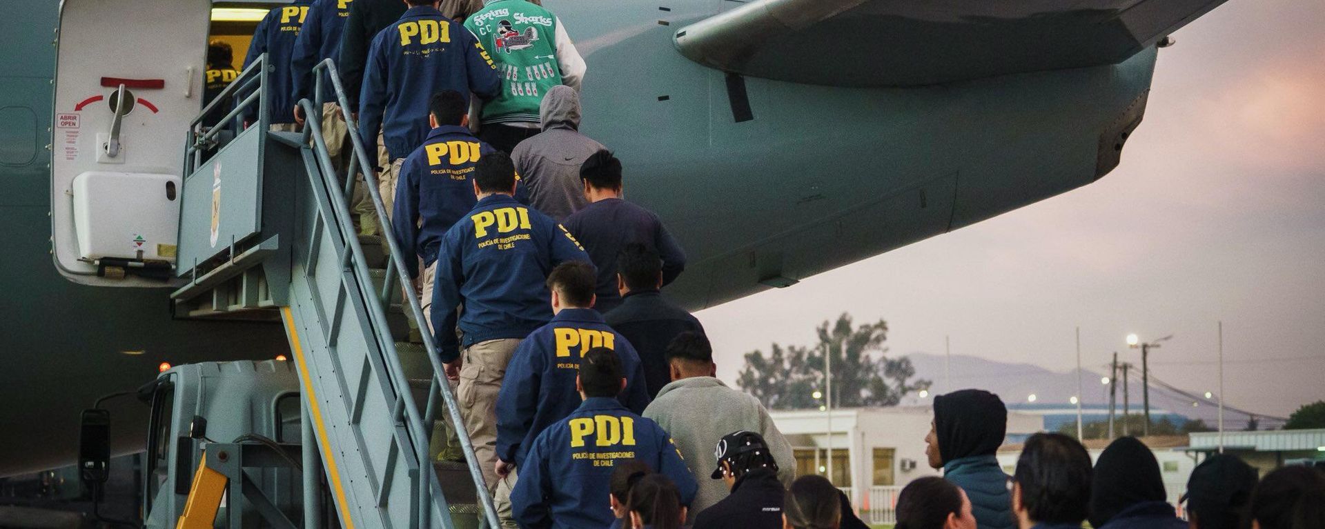 Migrantes irregulares en Chile siendo deportados en un vuelo, escoltados por efectivos de la Policía de Investigaciones (PDI) en abril de 2026 - Sputnik Brasil, 1920, 09.09.2026